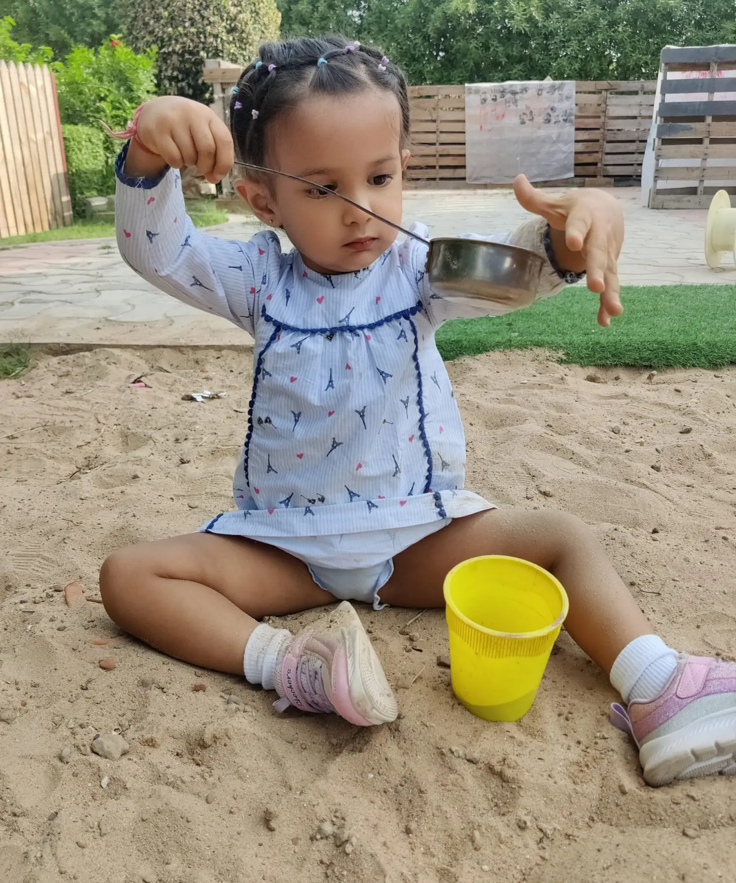 A Girl setting in sand and play with sand