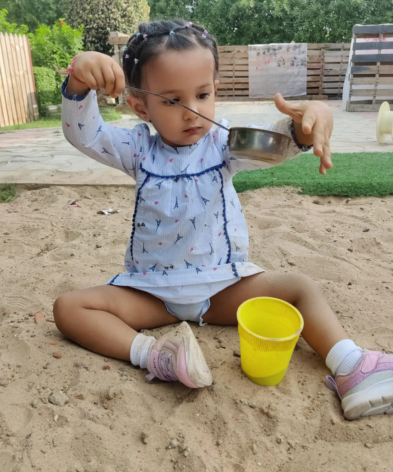 A Girl setting in sand and play with sand at sneha's Imagination Station