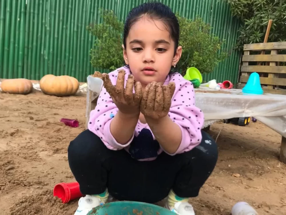A Girl Play with Sand in Toddler Play Program