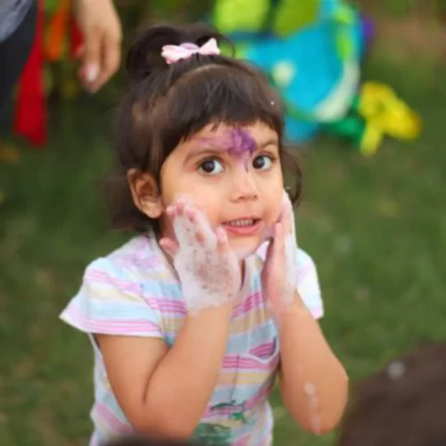 A Toddler Rubbing her chicks with her hand